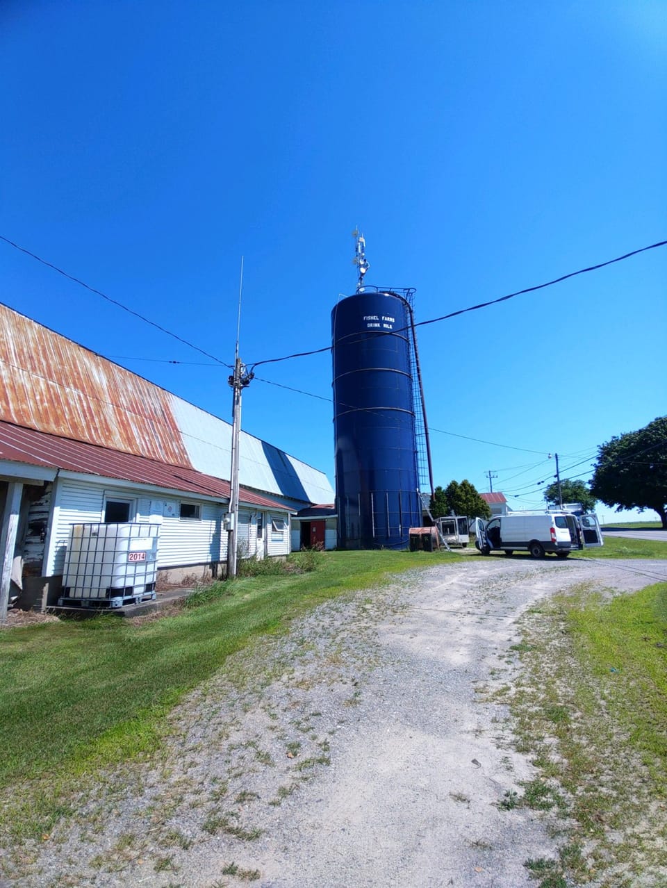 Rural field site with connectivity equipment and a service vehicle.